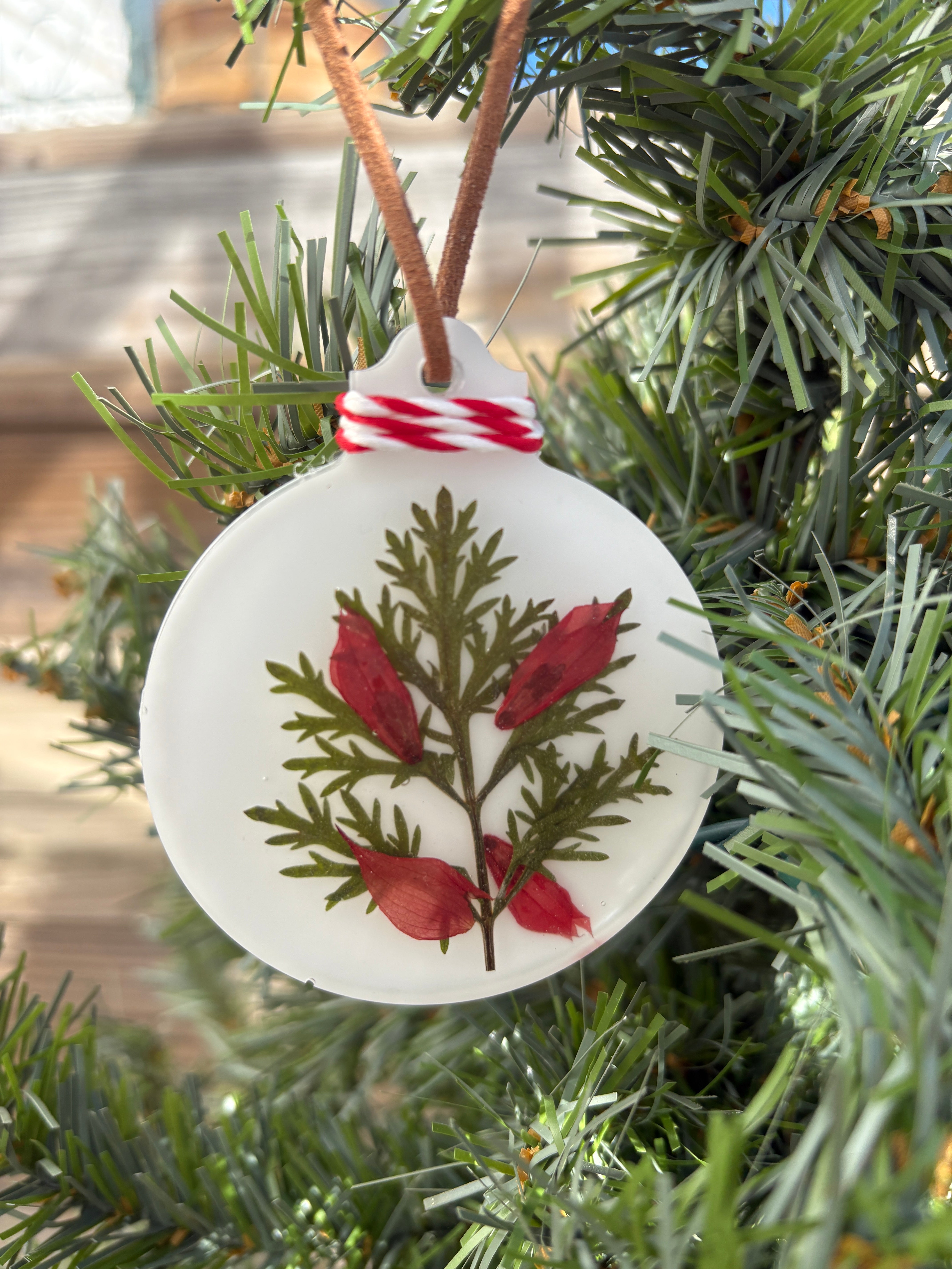 Salvia and Artemisia pressed flower ornament in white resin on red and white twine